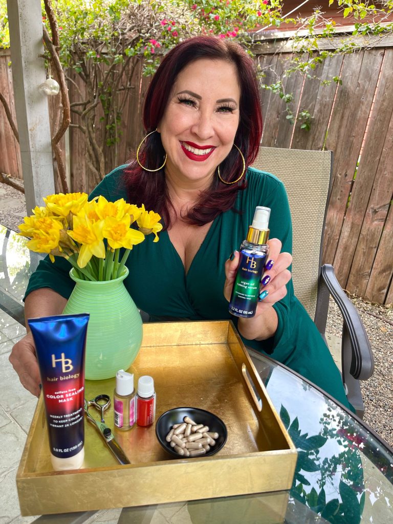 woman in green top holding hair serum