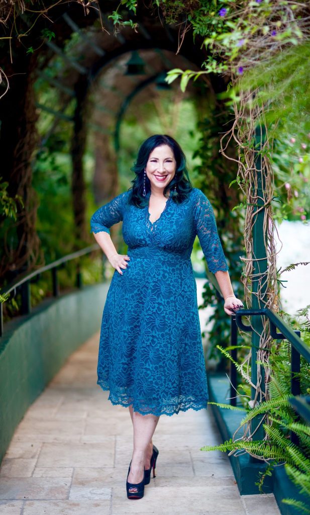 Plus size woman in blue lace dress for a special occasion.