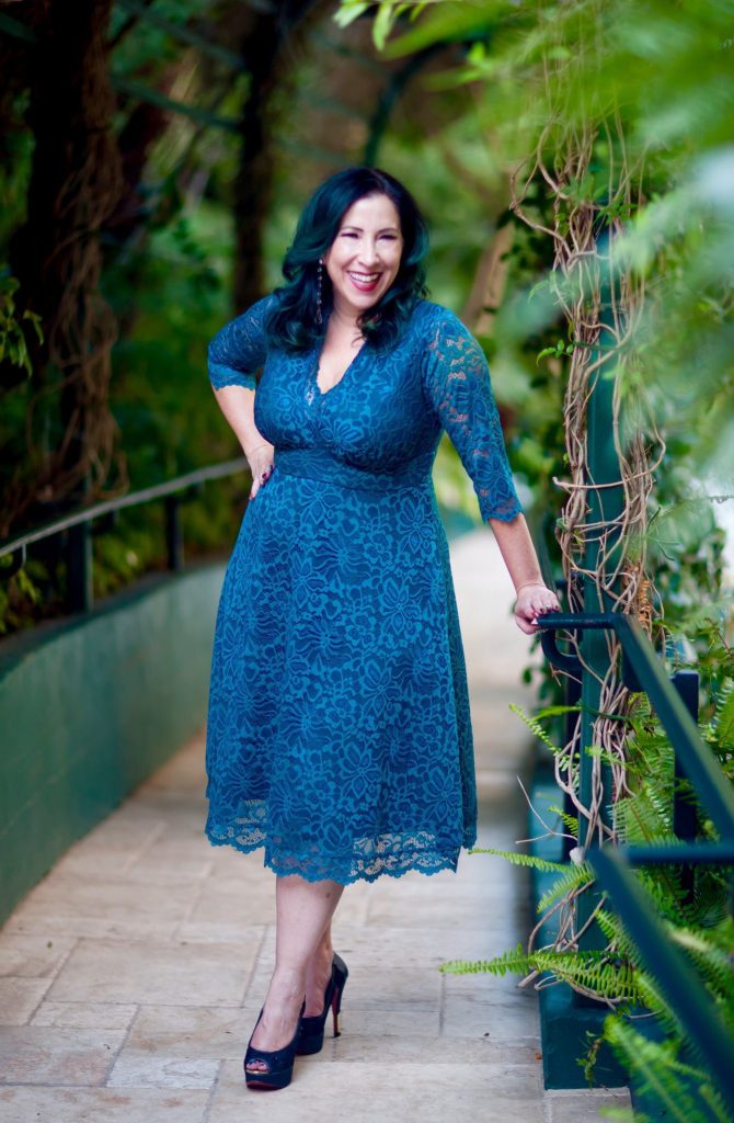 Brunette woman wearing a plus size dress made by Kiyonna. 