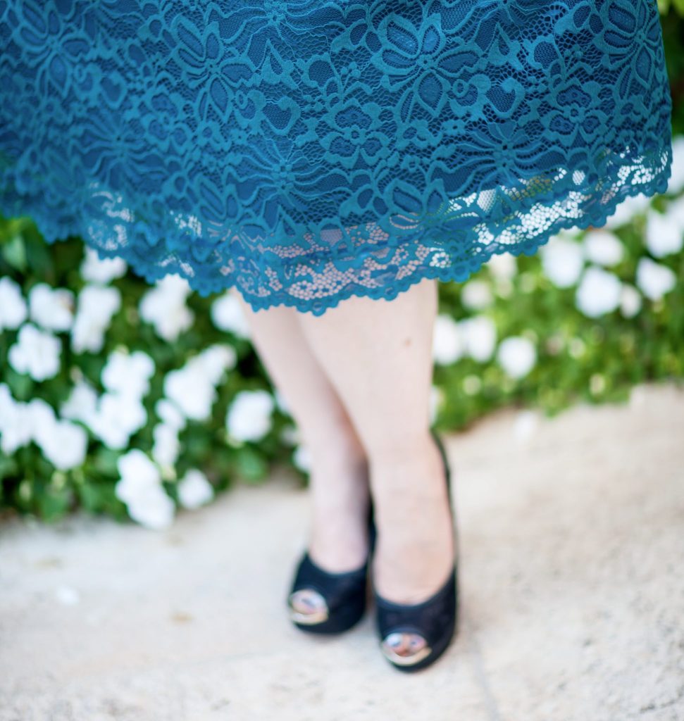 Close up detail of the scallop edge on a turquoise lace dress from Kiyonna. 