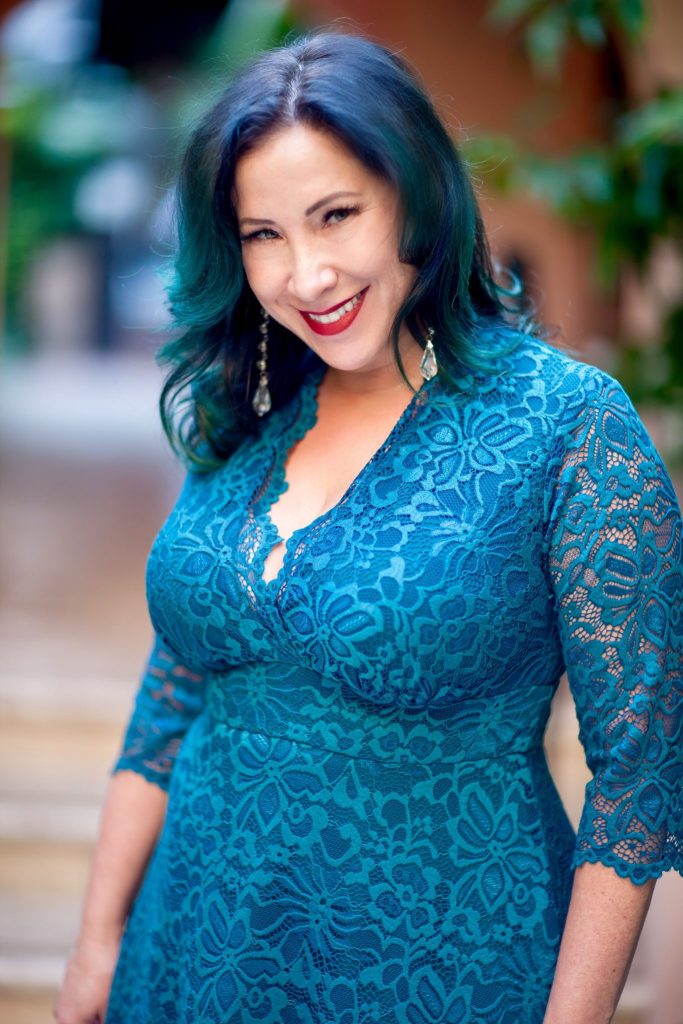 Close up of a woman in a blue lace dress. 